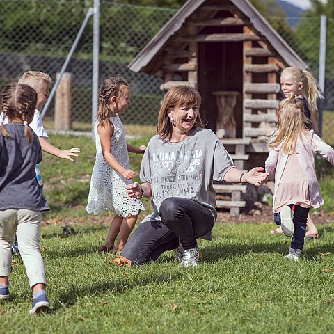 Landesrätin Palfrader mit Kindern auf Wiese spielend