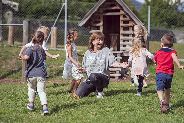 Landesrätin Palfrader mit Kindern auf Wiese spielend