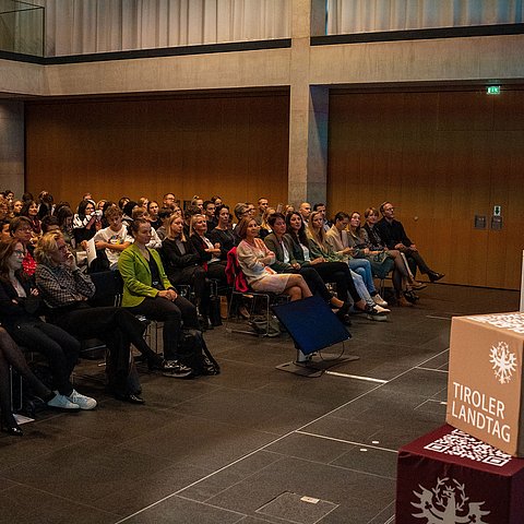 Moderatorin und Psychologin Birgit Oberhollenzer begrüßt die rund 150 Gäste im Tiroler Landhaus.