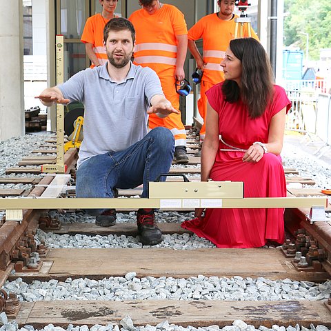 Bahngleise, Mann erklärt Kircher mit Gesten etwas