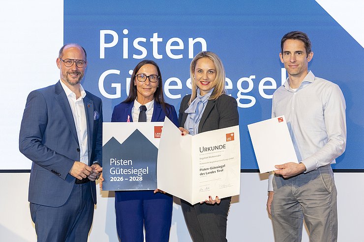 Vier Menschen sind bei einem Gruppenbild zu sehen.