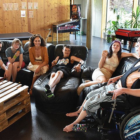 LRin und Jugendliche sitzen auf Couch und in Sesseln, Jugendliche essen Kekse