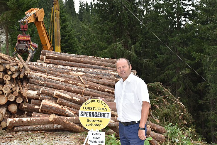 Josef Geisler vor Sperrschild im Wald