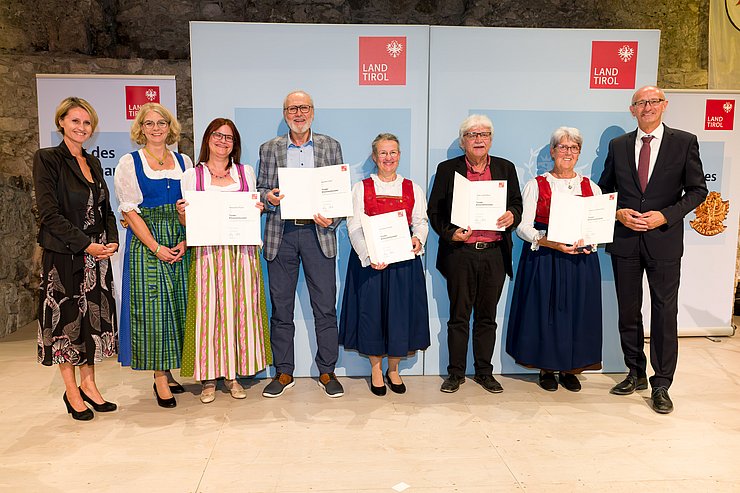 Bezirkshauptfrau Katharina Rumpf, Gemeindevorständin der Marktgemeinde Reutte Daniela Rief und LH Anton Mattle stehen gemeinsam mit den Geehrten der Gemeinde Reutte bei einem Gruppenfoto zusammen