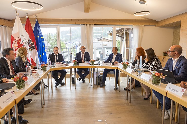 Die Tiroler Landesregierung sitzt gemeinsam an mehreren Tischen.