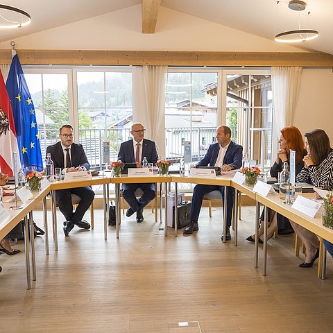 Die Tiroler Landesregierung sitzt gemeinsam an mehreren Tischen.