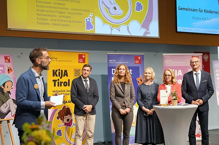 Personen stehen am Podium