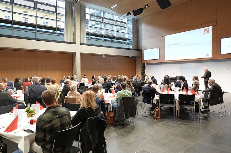 © Land Tirol/Reiter Viele Menschen sitzen an mehreren Tischen zusammen.