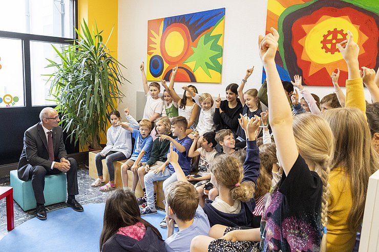 Foto von Landeshauptmann Anton Mattle und einigen SchülerInnen, die aufzeigen, weil sie eine Frage an den Landeshauptmann stellen wollen. 