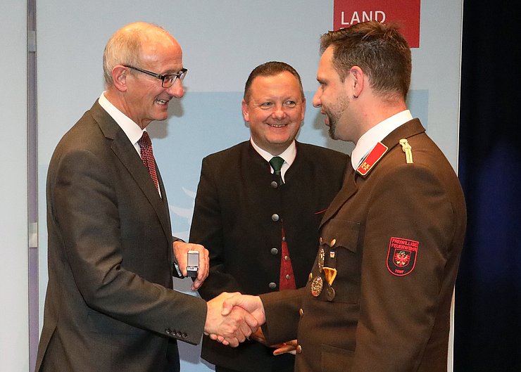 © Land Tirol/Frischauf-Bild Der Landeshauptmann schüttelt dem Geehrten Hannes Kröll die Hand.