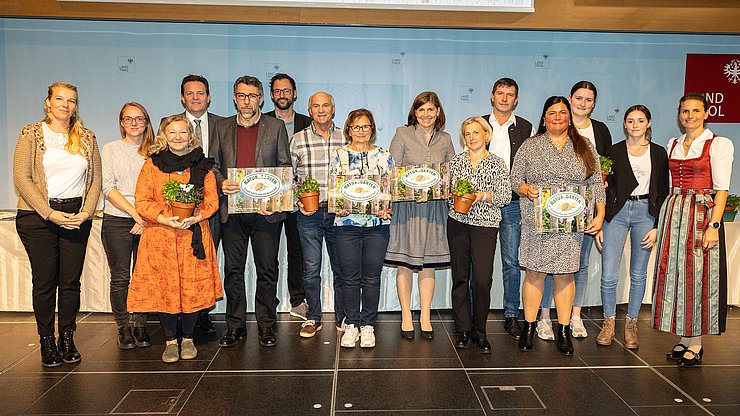 LR René Zumtobel (4.v.li.), Obfrau des Tiroler Bildungsforum Bettina Ellinger (1.v.re.) und Matthias Karader, Projektkoordinator Natur im Garten (6.v.li.), GemeindevertreterInnen und Natur im Garten BeraterInnen des Tiroler Bildungsforum mit Geehrten aus dem Bezirk Kufstein.
