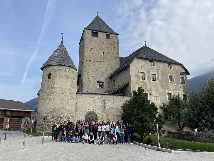 Gruppe von Jugendlichen posiert vor Burg/Schloss