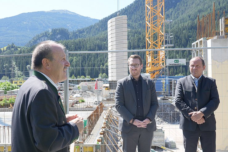 Drei Männer vor Baustelle