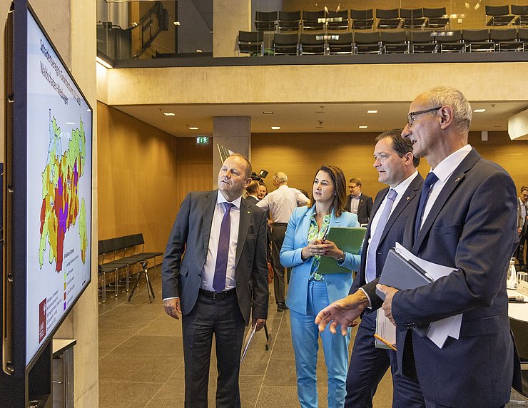 © Land Tirol/Die Fotografen (v.li.): Forstreferent des Landes LHStv Josef Geisler, Sicherheitslandesrätin Astrid Mair, Landwirtschaftsminister Norbert Totschnig und LH Anton Mattle diskutieren die Schäden im Tiroler Wald, dargestellt auf einer Karte.