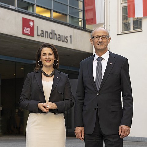Auf dem Foto sieht man Landeshauptmann Anton Mattle und Arbeitslandesrätin Astrid Mair im Innenhofe des Landhauses 1 stehen. 