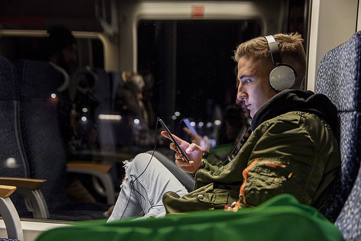© Verkehrsverbund Tirol/Pirkner Junger Mann in einer Bahn bei Nacht