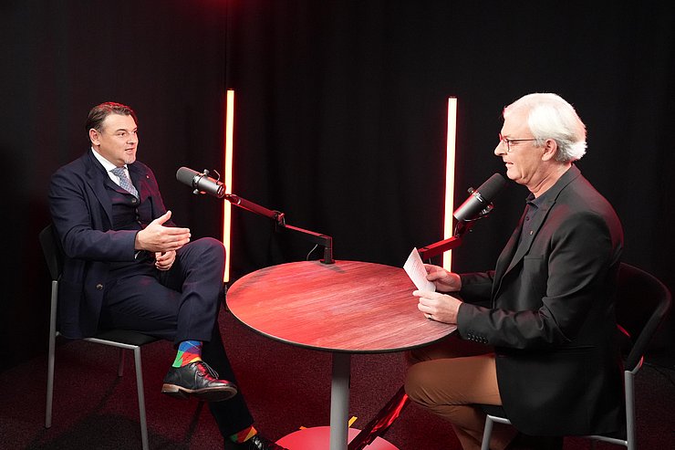 © Land Tirol/Dominik Personen sitzen an Tisch vor Mikro