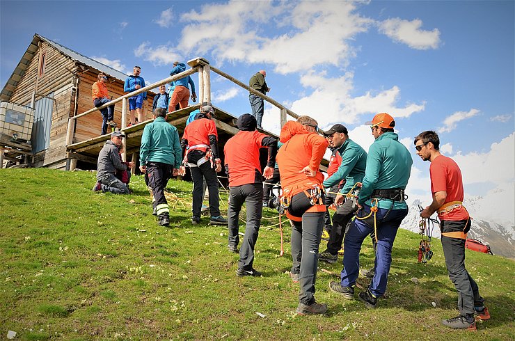 Bergretter vor einer Hütte am Hang