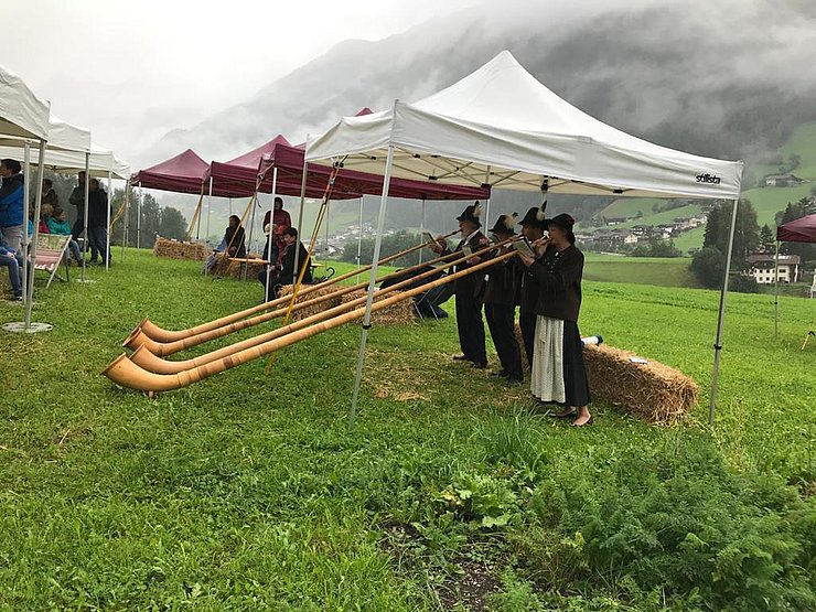 4 Personen blasen Alpenhörner