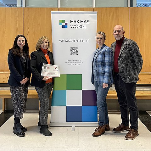 Personen stehen mit Aufkleber vor Rollup der Schule