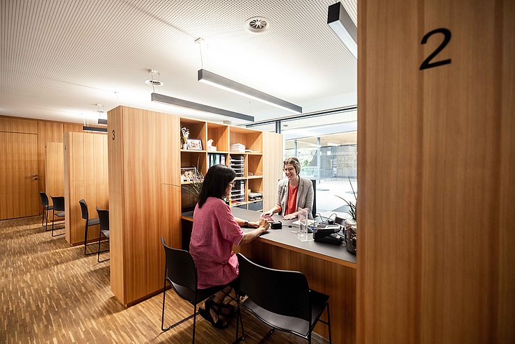 Bürgerin sitzt bei Bürgerservice einer Bezirkshauptmannschaft und wird beraten