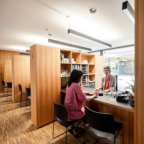 Bürgerin sitzt bei Bürgerservice einer Bezirkshauptmannschaft und wird beraten