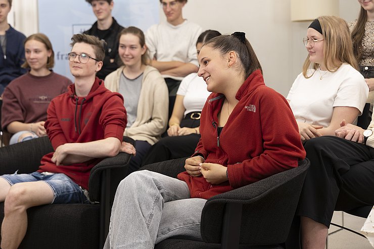 © Land Tirol/Die Fotografen Zwei SchülerInnen sitzen vor der Klasse und stellen die Fragen an den LH.