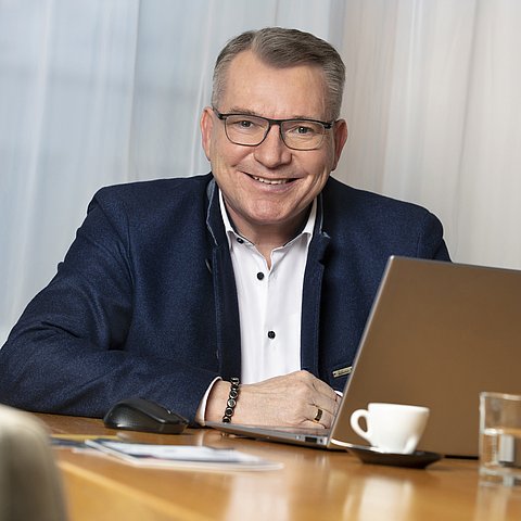 Portraitfoto Johannes Tratter vor Laptop sitzend