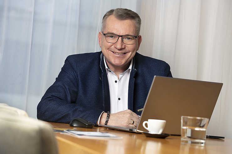Portraitfoto Johannes Tratter vor Laptop sitzend