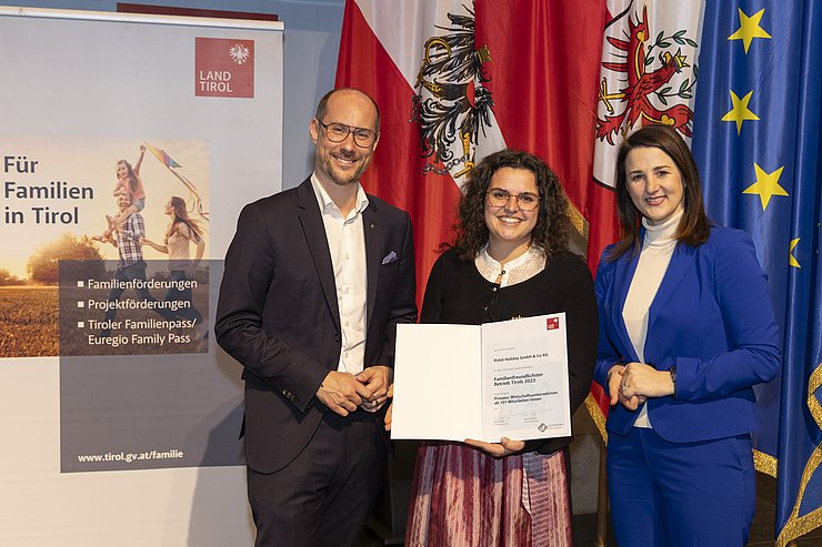 drei Personen mit Urkunde