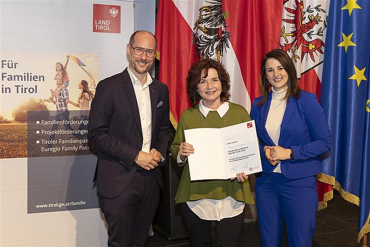 drei Personen mit Urkunde