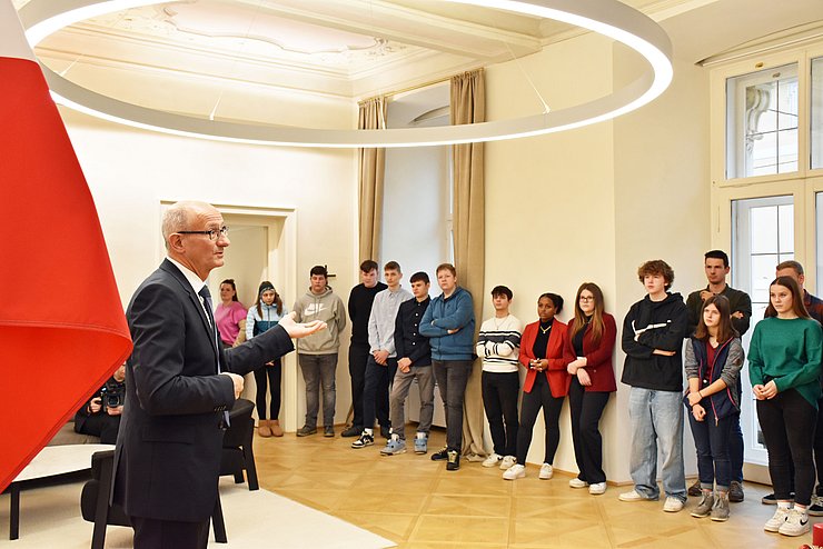 Die Lehrlinge stehen nebeneinander in einer Reihe im Büro des Landeshauptmanns und der Landeshauptmann spricht zu ihnen.