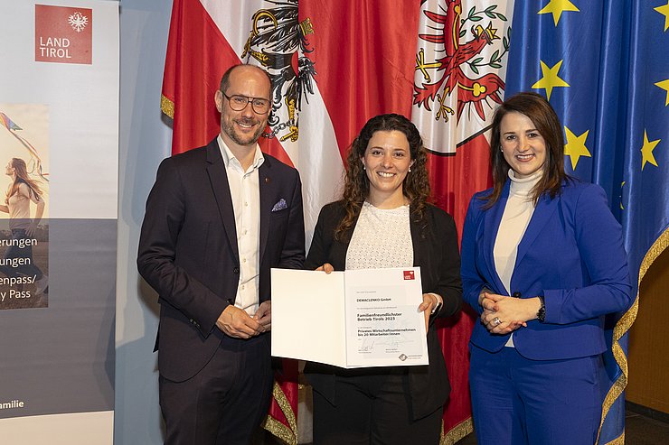 drei Personen mit Urkunde