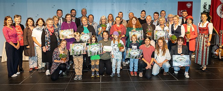 LR René Zumtobel (dritte Reihe, 1.v.li.), Obfrau des Tiroler Bildungsforum Bettina Ellinger (1.v.re.) und Matthias Karader, Projektkoordinator Natur im Garten (dritte Reihe, 2.v.li.), GemeindevertreterInnen und Natur im Garten BeraterInnen des Tiroler Bildungsforum mit Geehrten aus dem Bezirk Innsbruck-Land, Region West.