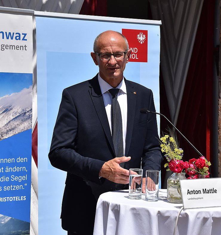 LH Anton Mattle steht bei der Pressekonferenz hinter einem weißen Tisch.