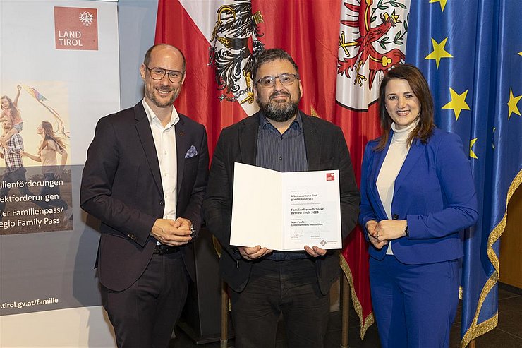 drei Personen mit Urkunde