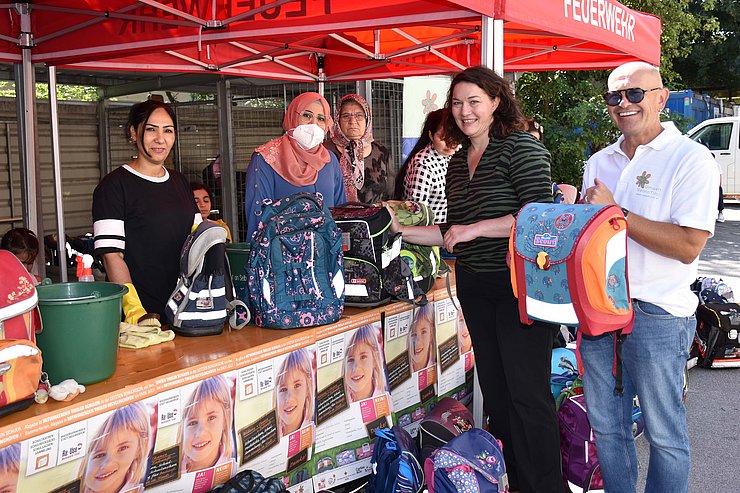 © Land Tirol/Dorfmann Felipe und Baumann mit Schultaschen, bei Stand der freiwilligen HelferInnen
