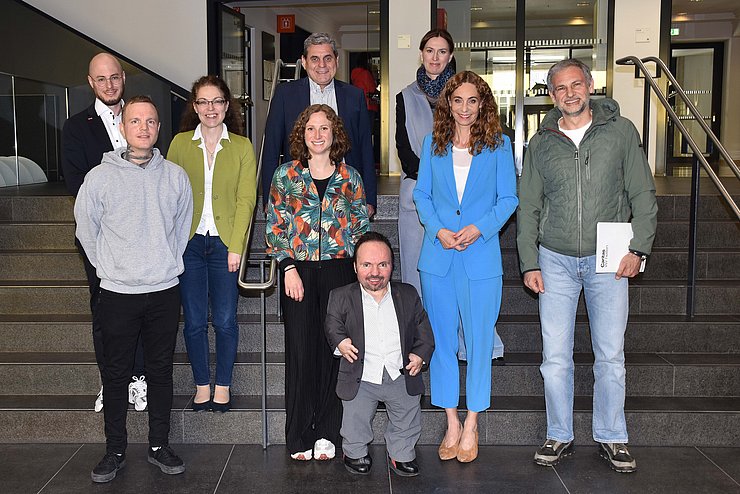 Personen stehen nebeneinander auf Treppe