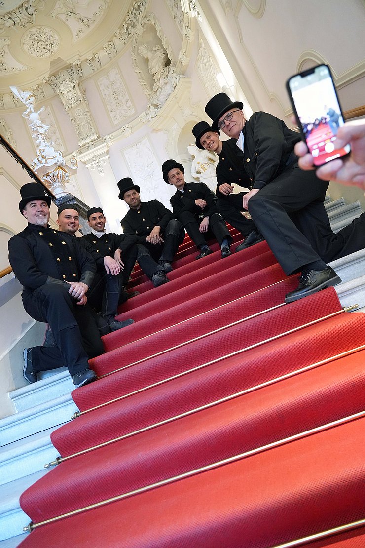 © Land Tirol/Neuner Mehrere Rauchfangkehrer sitzen auf einer Treppe.
