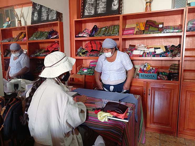 Laden mit zwei Frauen, auf dem Tisch: Textilien