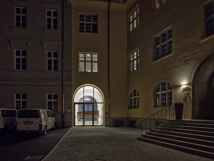 © Günter Richard Wett Nacht: Gebäude mit leuchtenden Eingangsbereich