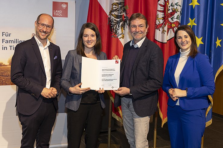 vier Personen mit Urkunde