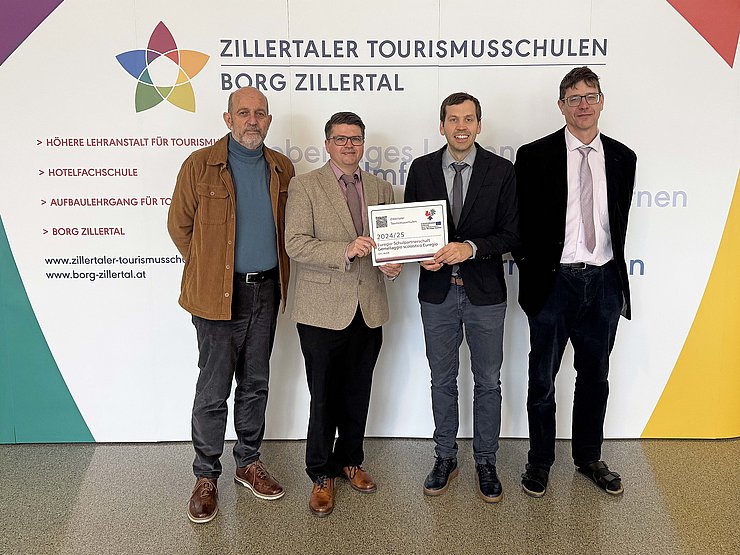 © Euregio Personen halten Aufkleber, stehen vor Plakat der Schule