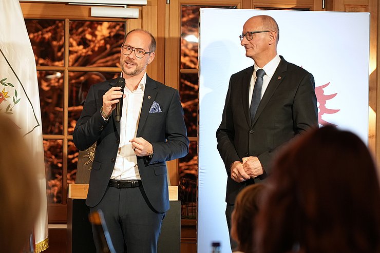 © Land Tirol/Pichler LR Gerber beim Reden auf Bühne, LH Mattle daneben