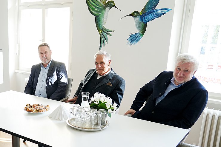 © Land Tirol/Neuner Nahaufnahme der drei Männer am Tisch.