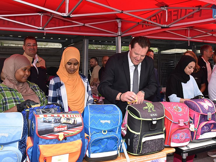 Zumtobel reinigt gemeinsam mit Flüchtlingen gebrauchte Schultaschen