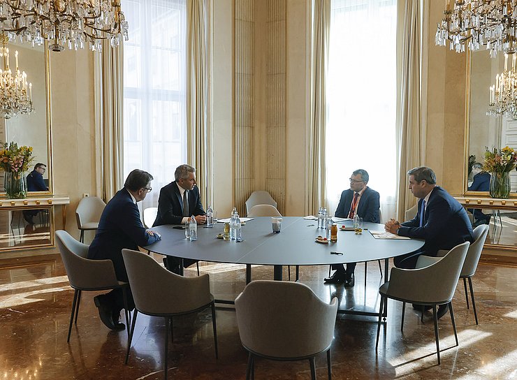 © Bundeskanzleramt/Dragan Tatic Platter, Nehammer, Herrmann und Söder sitzen an einem großen runden Tisch