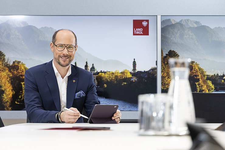 © Land Tirol/Die Fotografen Mario Gerber sitzt mit Tablet am Tisch