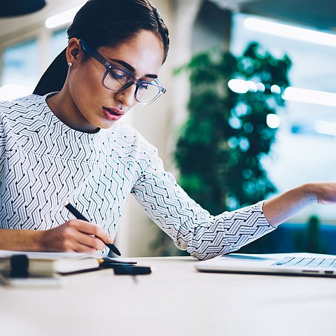 Frau mit Laptop und Stift