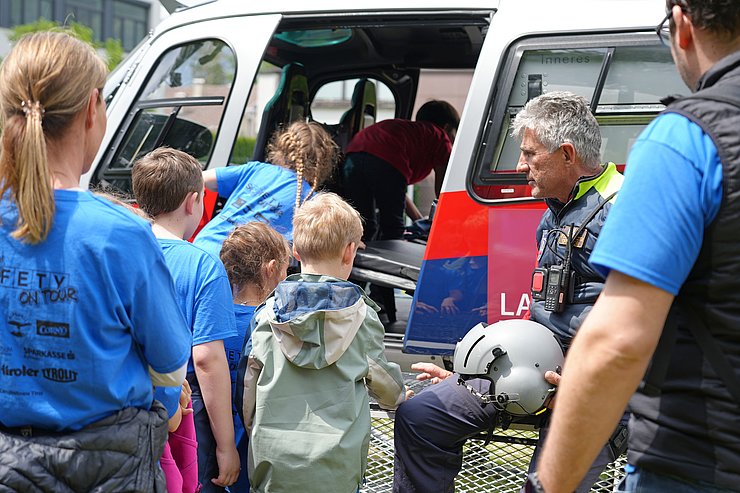 © Land Tirol/Reiter Kinder steigen in einen Helikopter ein.